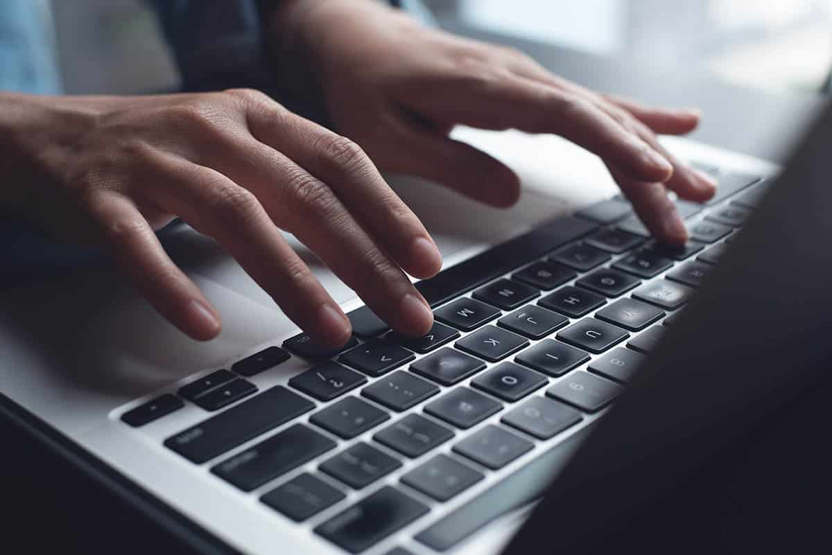 Close up of business woman hands typing on laptop computer and digital tablet, searching and surfing the internet on office desk, online working, telecommuting, freelancer at work concept